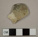 Burned earthenware, possibly creamware, plate rim sherd