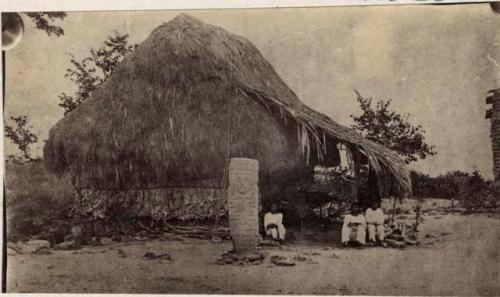 Idol from Tehuantepec Region - looks like Mayan stela in front of grass house