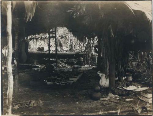 Collection of decorated bowls and other pottery under a hut