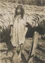 Man posed in front of hut