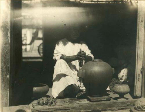 Tikul woman modelling a clay jar