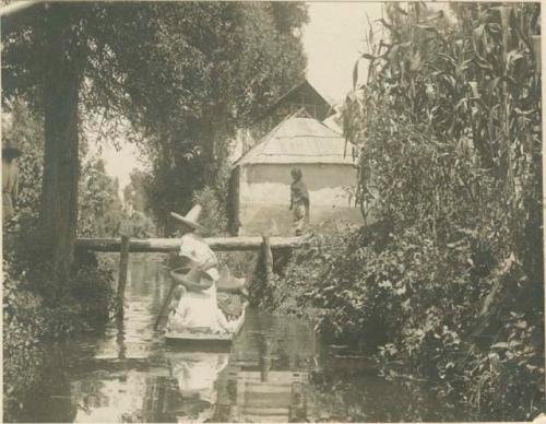 Young girl crossing footbridge as men pass below in a chalupa