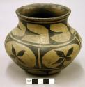 Small pottery jar. Concavity in base, globular with out-curving neck, red ware