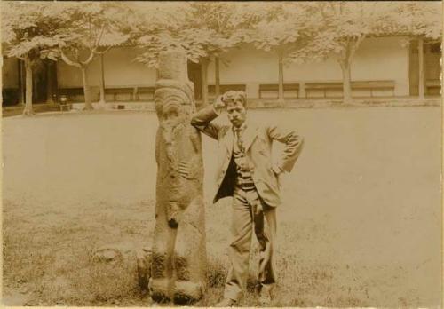 Man posing with stone sculpture