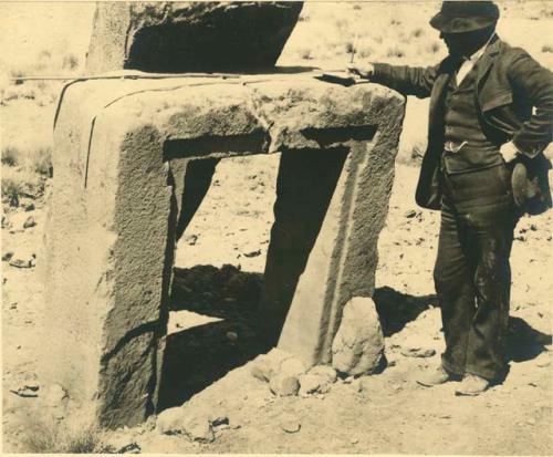 Man standing beside small stone gateway