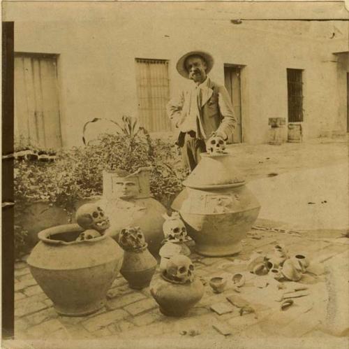 Man with skulls and pottery from tombs in Santa Marta