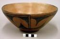 Pottery bowl. Flat base, slightly flaring sides, light reddish brown slip on bo