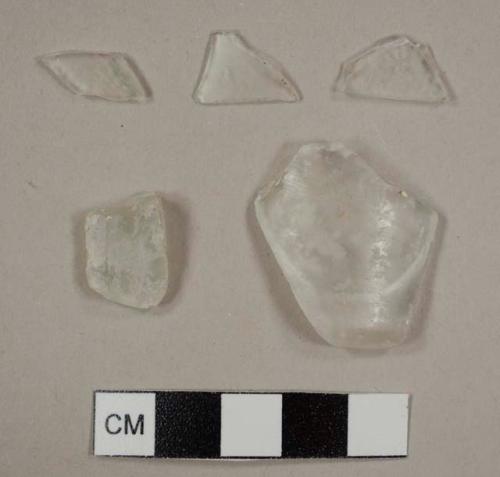 Colorless curved glass fragments, including one possible tumbler fragment and one possible lamp glass fragment