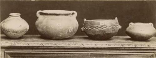 Three clay jars and an ornamented cup