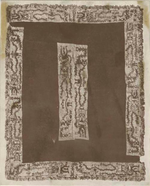 Dark red cloth, decorated with ten bands of similar figures, and ornamented with a fringe.