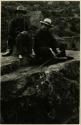 Two men sit at ruins of Pisac