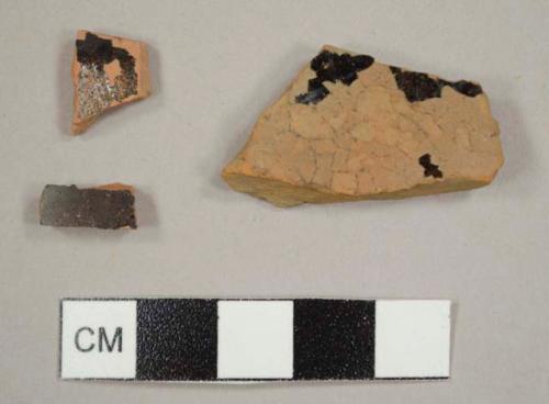 Red earthenware sherds with black and clear/yellowish lead glaze on both sides