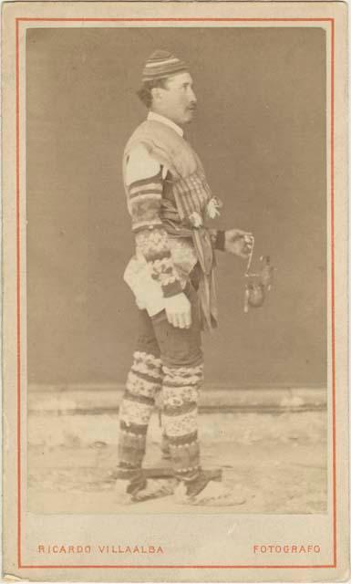 Man dressed in woven textiles, holding object