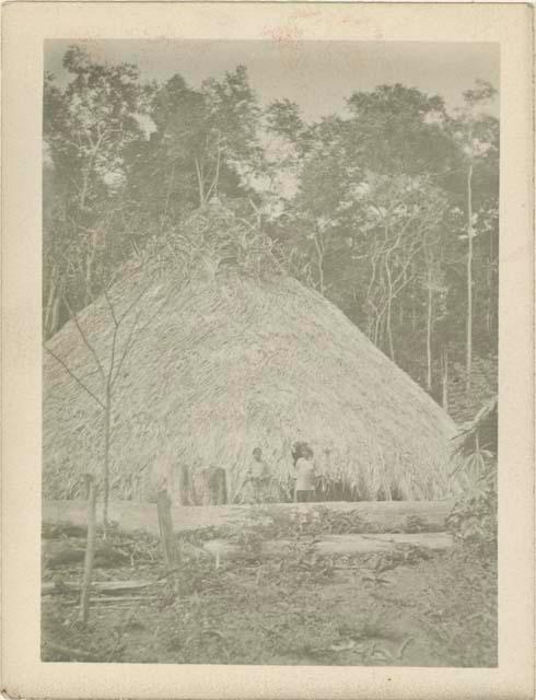 Two people in front of house