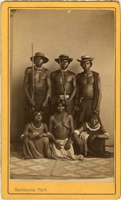 Studio portrait of a group of three men standing and three women squatting