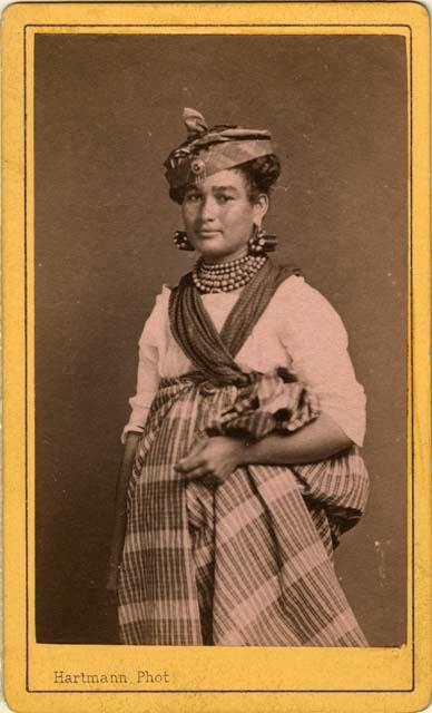 Woman standing with hat, jewelry