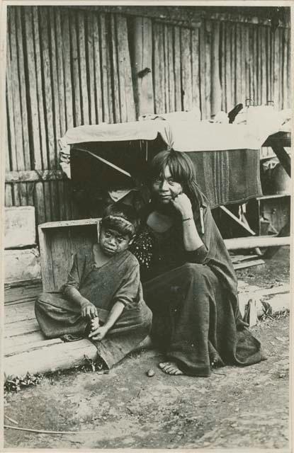 Woman and child in front of structure