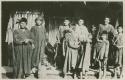 Group of men and boys standing in front of a structure