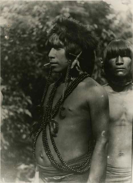 Profile view of man wearing long strings of beads