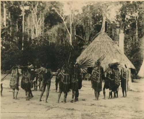 Men dancing in front of house