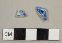 Blue-on-white transfer-printed pearlware fragments, including one plate rim sherd with blue decoration on both sides