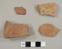 Three red brick fragments and one stone fragment, possibly pink granite