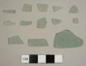 Thirteen aqua flat glass fragments and one curved aqua glass fragment