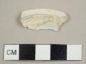 Pearlware lid sherd with small fragments of blue decoration