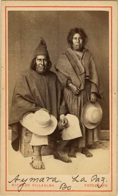 Studio staged portrait of woman and seated man