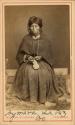 Studio staged portrait of seated woman