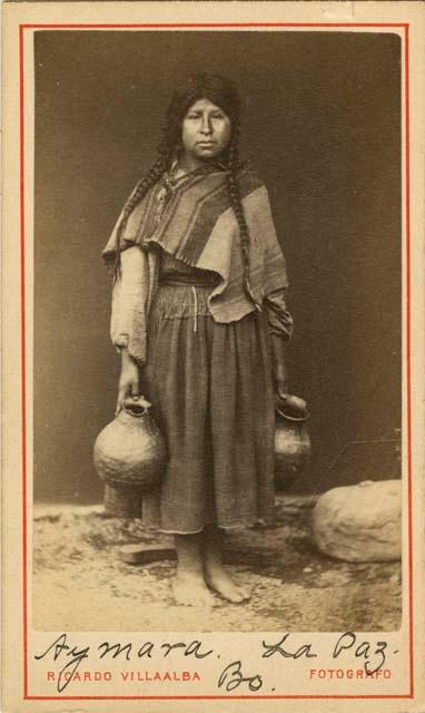 Studio portrait of woman holding two ceramic vessels