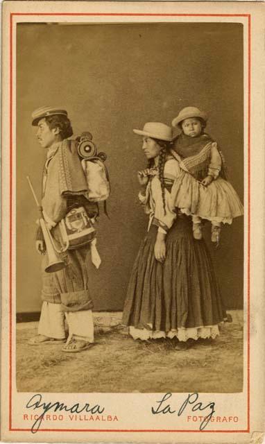 Studio portrait of man and woman carrying child