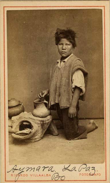 Studio staged portrait of kneeling boy