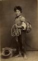 Studio portrait of boy with rope, basket and bag