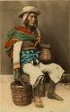 Studio portrait of man sitting with basket and ceramic vessel