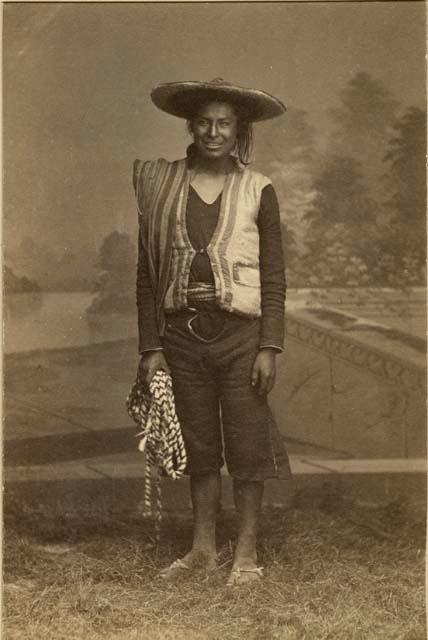 Studio portrait of man standing and holding rope