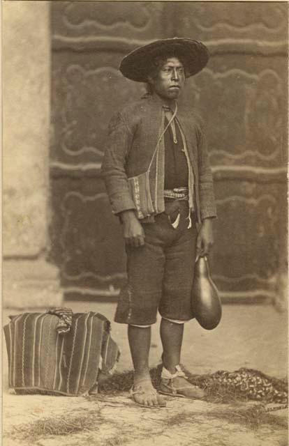 Studio portrait of man standing and holding a gourd