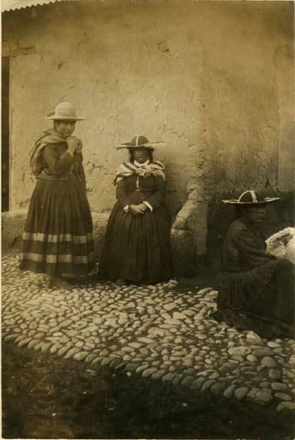 Three women next to a building