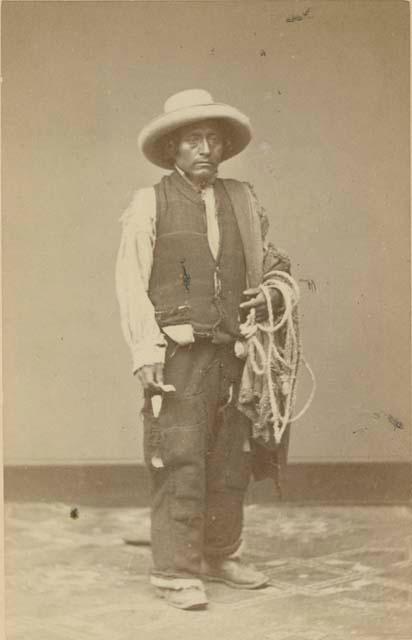 Studio portrait of man standing and holding rope