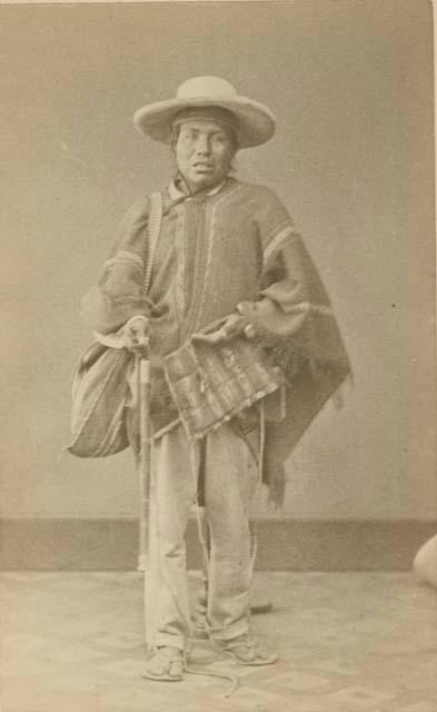 Studio portrait of man standing and carrying a woven bag