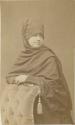 Studio portrait of woman leaning against a chair