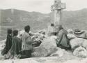 Group sitting around a stone cross