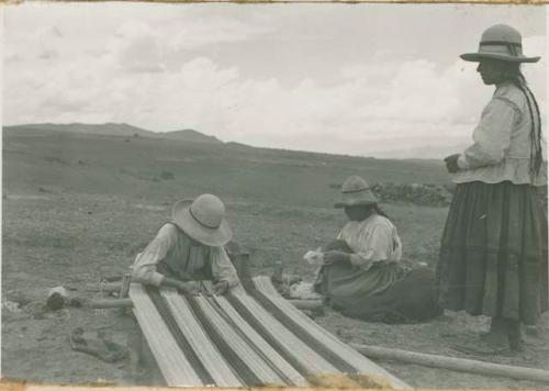 Three women weaving