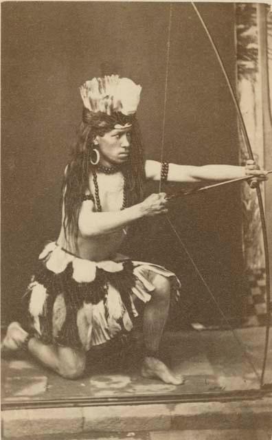 Studio portrait of man with bow and arrow