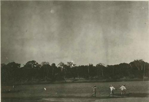 Three men walking along shoreline