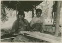 Woman and man sitting at a loom