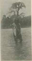 Man standing in water holding a fish