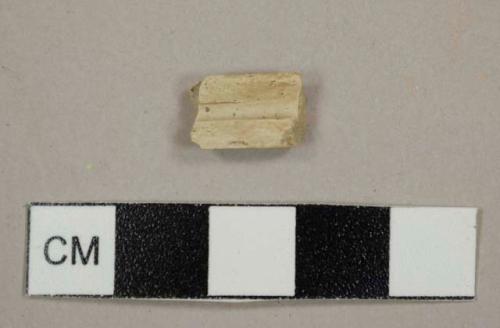 Kaolin/Ball clay pipe stem fragment with a slightly buff tint, split lengthwise, with a 5/64 inch bore diameter