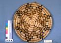Coiled basketry plate with polychrome geometric designs; small loop