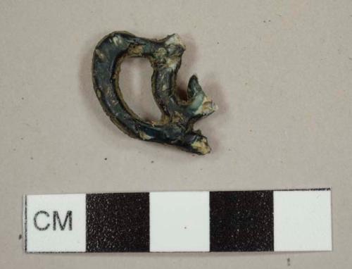 Plastic fragment shaped like a pretzel with a black exterior and white interior